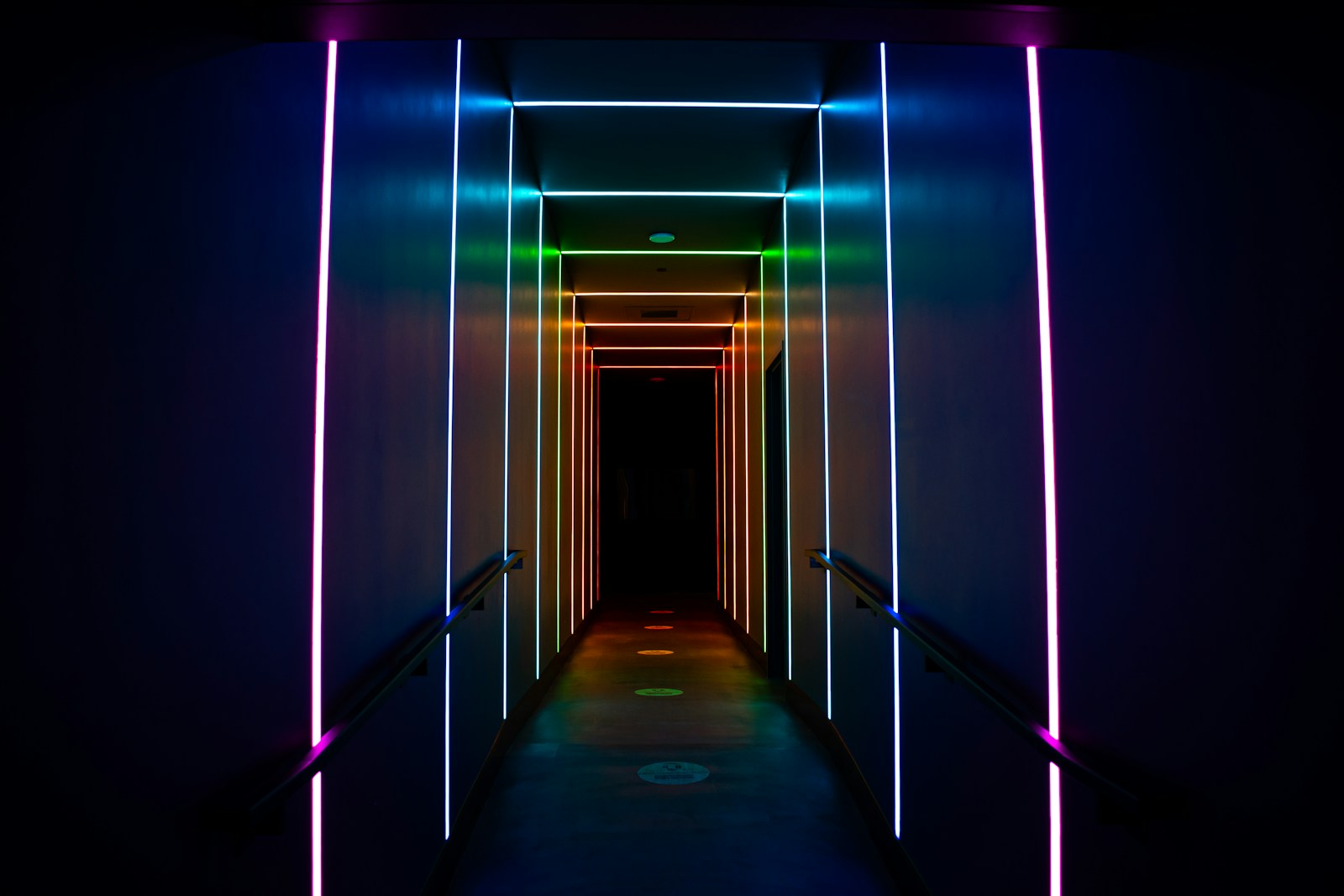 a long hallway with neon lights on the walls