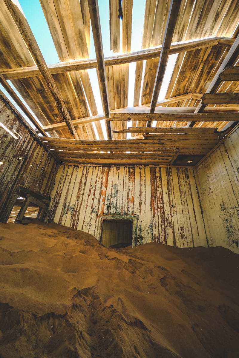 A room with a wooden floor and a pile of sand