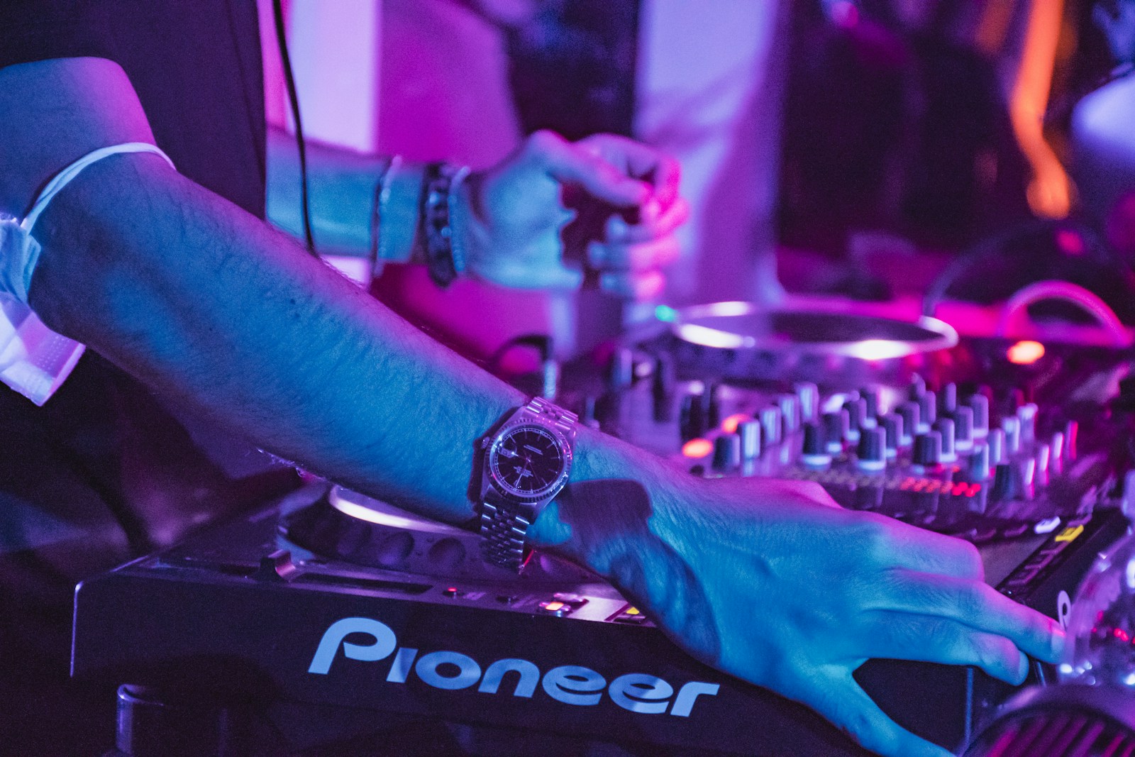 person wearing black and silver ring playing black and white audio mixer